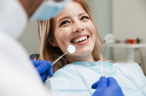Dentist and team member talking to a man sitting in the dental chair